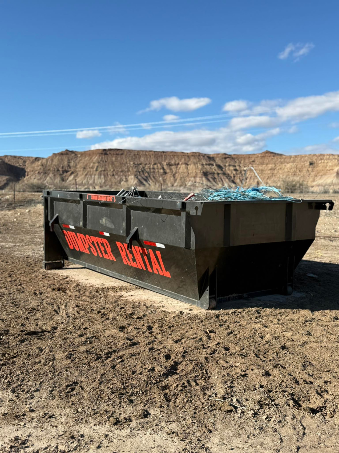 Outlaw Willy's 15-yard dumpster set on a property below a Uintah Basin bluff
